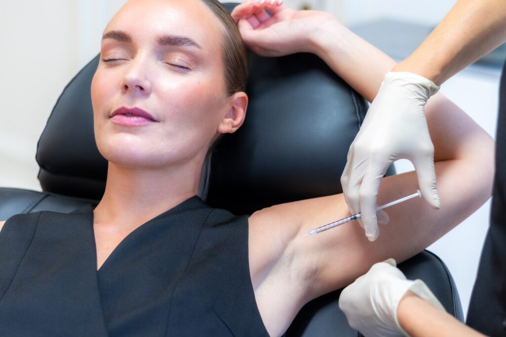 Nærbillede af botoxbehandling i armhulen, patienten ligger med armen over hovedet