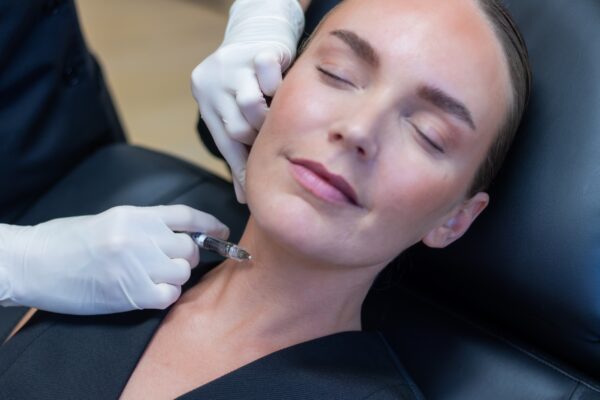 Nærbillede af skinbooster ved kæbelinjen og halsen